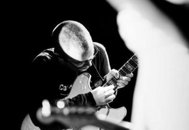Black and white shot of David Porteous playing guitar